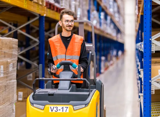 Orderpicker uitzendkracht van N2 People in een magazijn rijdt op een gele orderpicker